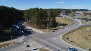 Oro nuotrauka, vaizduojanti judrią transporto sankryžą Vilniaus mieste saulėtą dieną.