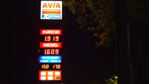 Degalų kainas rodanti šviečianti stotelės iškaba tamsiu paros metu Europos mieste.