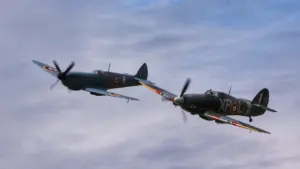 Antrojo pasaulinio karo „Spitfire“ ir „Hurricane“ naikintuvai skrenda kartu danguje.