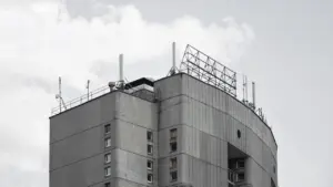 Daugiaaukštis betoninis pastatas Vilniuje su ant stogo sumontuotomis telekomunikacijų antenomis
