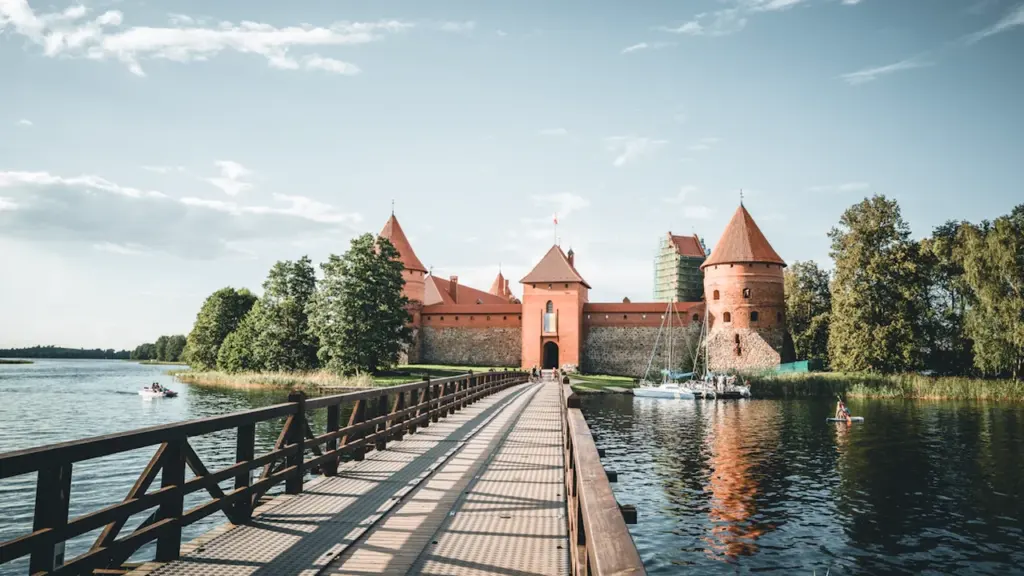 Trakų salos pilis ir pėsčiųjų tiltas saulėtą dieną, garsusis Lietuvos kultūros paminklas.